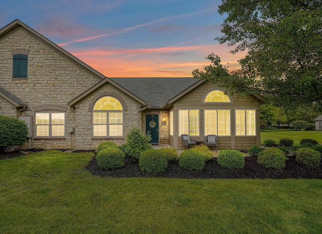 6973 Falls View Cir, Delaware, OH 43015 - view of front of house featuring stone siding, a yard, and roof with shingles
