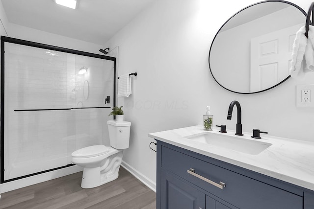1191 Seymour Ave, Columbus, OH 43206 - bathroom with vanity, toilet, wood finished floors, a shower stall, and baseboards