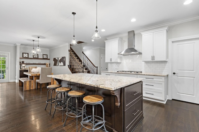 4477 Ackerly Farm Rd, New Albany, OH 43054 - kitchen featuring wall chimney range hood, stainless steel gas cooktop, a center island, dark wood finished floors, and tasteful backsplash