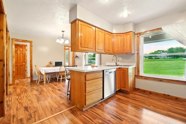 19160 Coshocton Rd, Mount Vernon, OH 43050 - kitchen featuring dishwasher, light wood-type flooring, a peninsula, a textured ceiling, and a chandelier