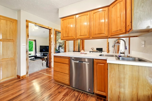 19160 Coshocton Rd, Mount Vernon, OH 43050 - kitchen with stainless steel dishwasher, a sink, light wood-style floors, light countertops, and a textured ceiling