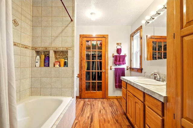 19160 Coshocton Rd, Mount Vernon, OH 43050 - bathroom with vanity, wood finished floors, tiled shower / bath combo, and a textured ceiling