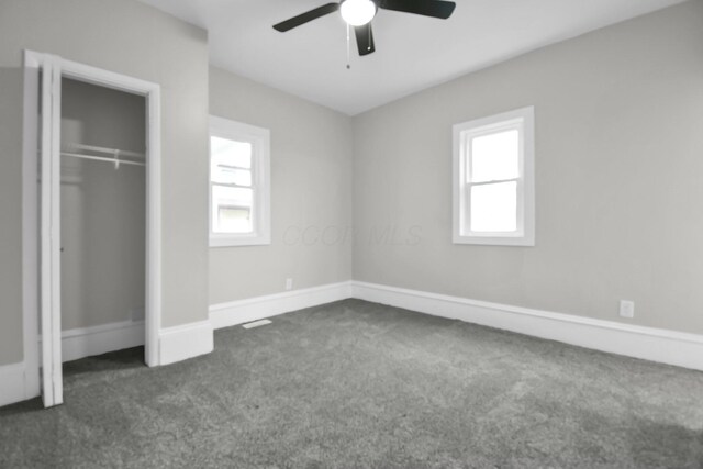 44 W 4th St, Fredericktown, OH 43019 - unfurnished bedroom featuring dark carpet, multiple windows, a closet, and ceiling fan