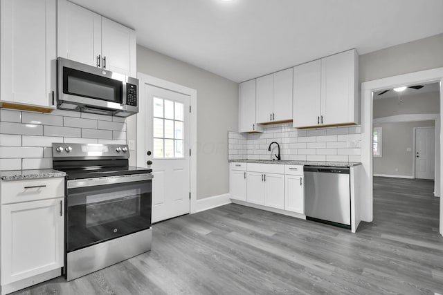 44 W 4th St, Fredericktown, OH 43019 - kitchen featuring appliances with stainless steel finishes, baseboards, a sink, and backsplash