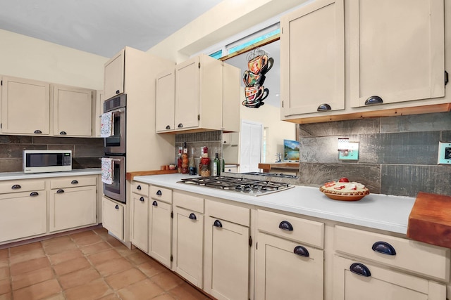 2149 Baptist Hill Rd, Chillicothe, OH 45601 - kitchen featuring appliances with stainless steel finishes, tasteful backsplash, light countertops, cream cabinetry, and light tile patterned flooring