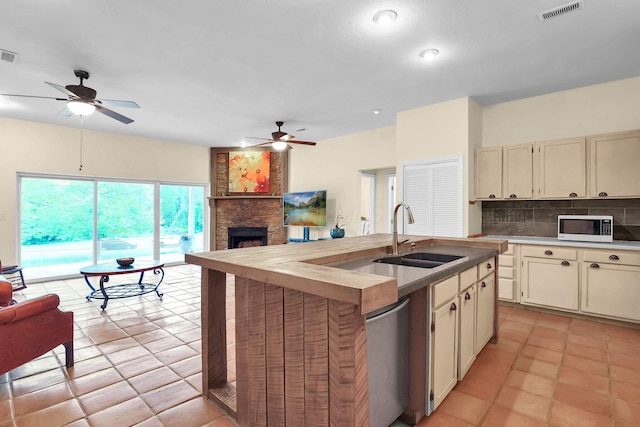 2149 Baptist Hill Rd, Chillicothe, OH 45601 - kitchen featuring a sink, white microwave, ceiling fan, open floor plan, and cream cabinetry