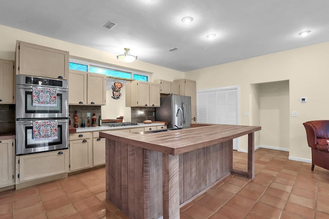 2149 Baptist Hill Rd, Chillicothe, OH 45601 - kitchen with stainless steel appliances, backsplash, wooden counters, an island with sink, and cream cabinets