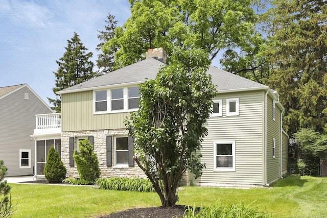 2615 NW Blvd, Upper Arlington, OH 43221 - view of front of home with a front yard, stone siding, a chimney, and a shingled roof