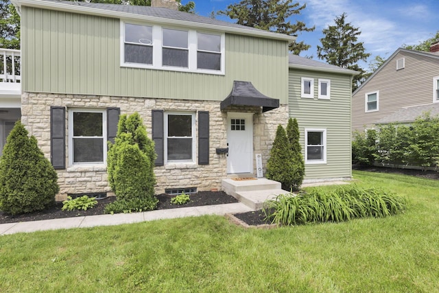 2615 NW Blvd, Upper Arlington, OH 43221 - view of front of house with stone siding, a front lawn, and a chimney