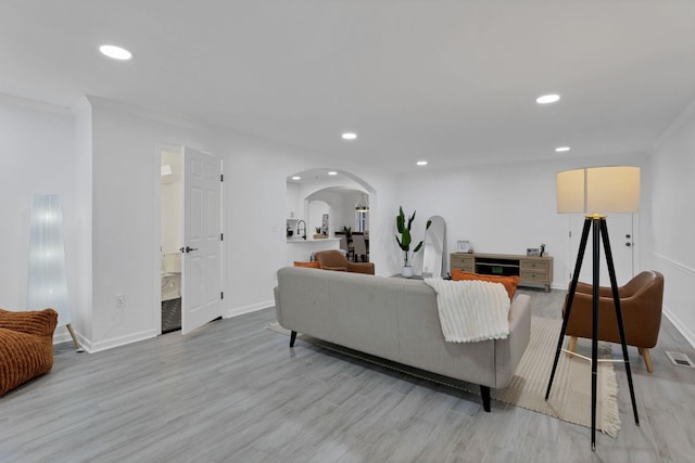 2615 NW Blvd, Upper Arlington, OH 43221 - living room with arched walkways, baseboards, recessed lighting, ornamental molding, and light wood-type flooring
