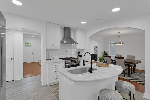 2615 NW Blvd, Upper Arlington, OH 43221 - kitchen with wall chimney range hood, stainless steel gas stove, a sink, backsplash, and white cabinets