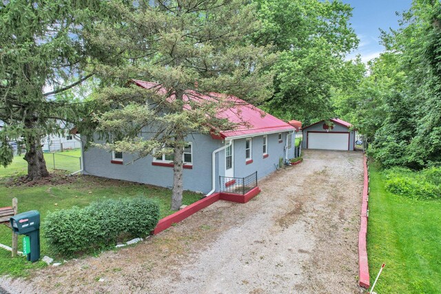 13424 Ivy Rd NE, Thornville, OH 43076 - view of front of home with an outdoor structure, a garage, stucco siding, and a front lawn
