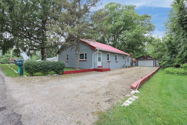 13424 Ivy Rd NE, Thornville, OH 43076 - view of front facade featuring a detached garage, an outbuilding, a metal roof, and a front lawn