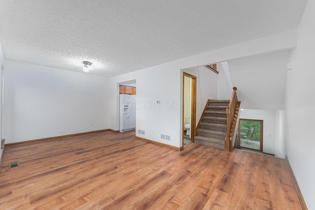 406 Olentangy Forest Dr Unit 9B, Columbus, OH 43214 - spare room with light wood-style floors, stairs, a textured ceiling, and baseboards