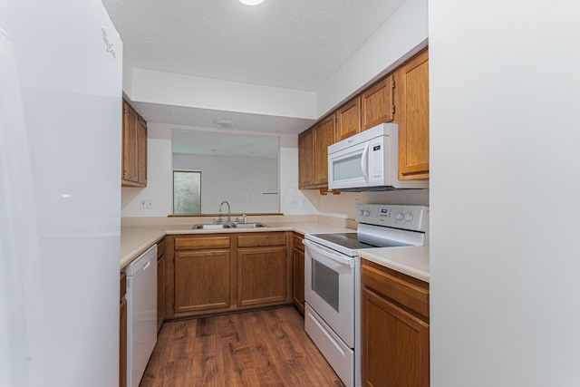 406 Olentangy Forest Dr Unit 9B, Columbus, OH 43214 - kitchen featuring white appliances, a sink, dark wood finished floors, light countertops, and brown cabinetry