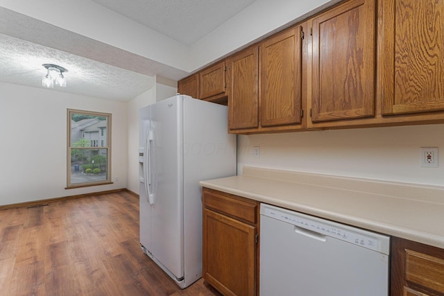 406 Olentangy Forest Dr Unit 9B, Columbus, OH 43214 - kitchen with white appliances, a textured ceiling, brown cabinets, dark wood-style floors, and light countertops