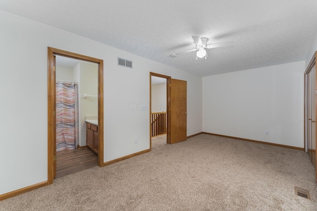 406 Olentangy Forest Dr Unit 9B, Columbus, OH 43214 - unfurnished bedroom with light colored carpet, a textured ceiling, baseboards, and ceiling fan