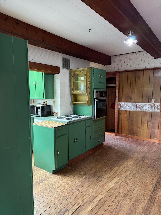 627 N Main St, Utica, OH 43080 - kitchen with green cabinetry, oven, light wood-style floors, stainless steel microwave, and beamed ceiling