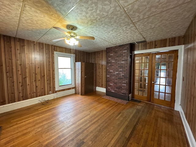627 N Main St, Utica, OH 43080 - spare room featuring hardwood / wood-style flooring, wood walls, ceiling fan, and french doors