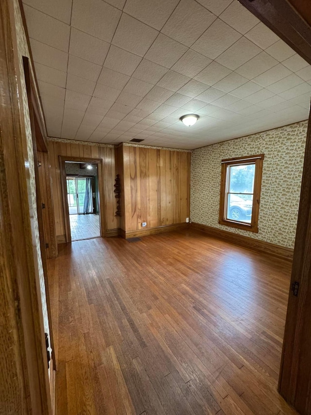 627 N Main St, Utica, OH 43080 - empty room with wood-type flooring, plenty of natural light, baseboards, and wood walls