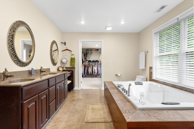 15027 King Rd, Howard, OH 43028 - bathroom with double vanity, a garden tub, toilet, a spacious closet, and recessed lighting