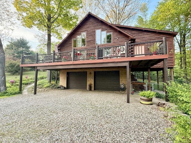 15626 Pleasant View Dr, Mount Vernon, OH 43050 - view of front facade with gravel driveway, an attached garage, a wooden deck, and log exterior
