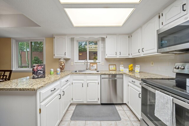 4129 Leitrim Ct, Dublin, OH 43016 - kitchen featuring appliances with stainless steel finishes, a sink, a peninsula, and white cabinetry