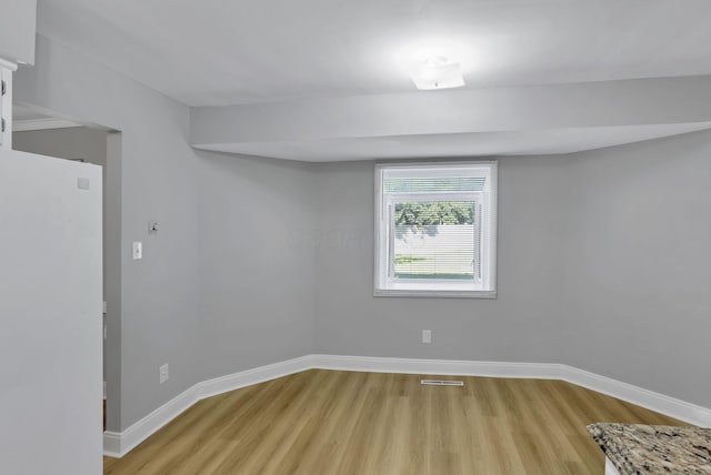 4230 Reed Rd, Columbus, OH 43220 - below grade area with freestanding refrigerator, light wood-type flooring, and baseboards