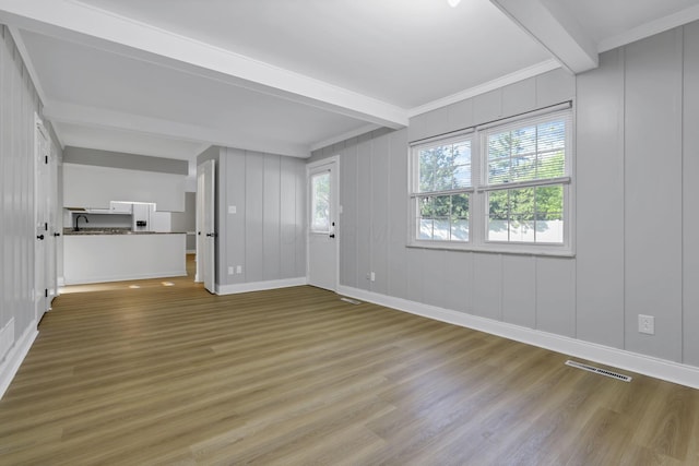 4230 Reed Rd, Columbus, OH 43220 - unfurnished living room with beamed ceiling, a decorative wall, wood finished floors, baseboards, and crown molding
