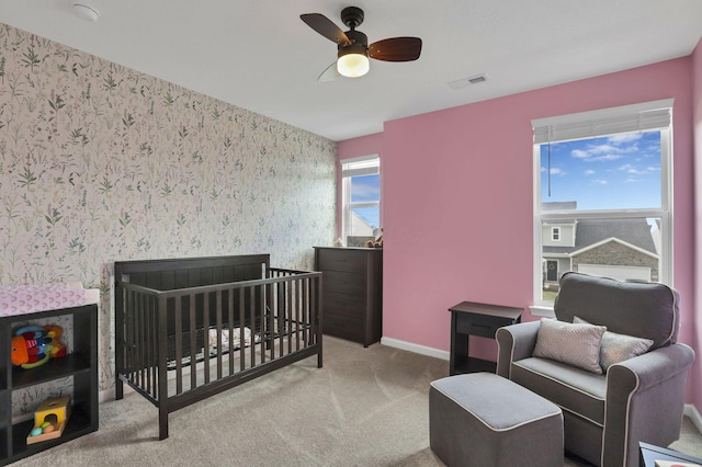 233 Dowler Dr, South Bloomfield, OH 43103 - bedroom with wallpapered walls, carpet floors, baseboards, a ceiling fan, and a crib