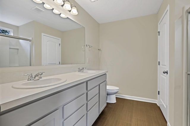 233 Dowler Dr, South Bloomfield, OH 43103 - full bath with double vanity, toilet, baseboards, and a shower with door