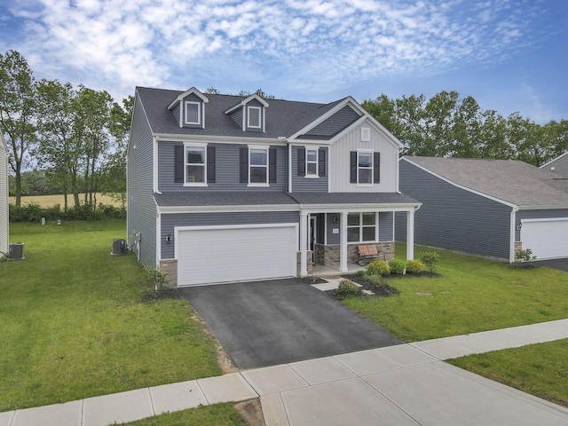 233 Dowler Dr, South Bloomfield, OH 43103 - view of front of property with a porch, driveway, a front lawn, stone siding, and an attached garage