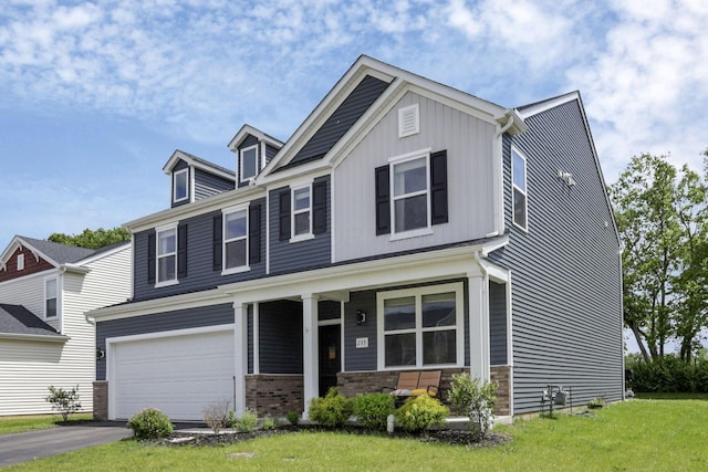 233 Dowler Dr, South Bloomfield, OH 43103 - craftsman-style home with covered porch, asphalt driveway, a front lawn, and a garage