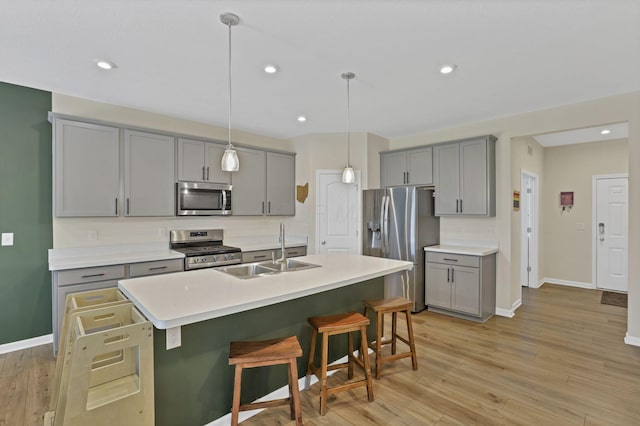 233 Dowler Dr, South Bloomfield, OH 43103 - kitchen featuring appliances with stainless steel finishes, gray cabinetry, a sink, a kitchen bar, and recessed lighting