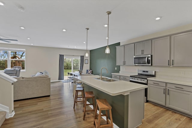 233 Dowler Dr, South Bloomfield, OH 43103 - kitchen featuring appliances with stainless steel finishes, gray cabinetry, a sink, open floor plan, and a center island with sink
