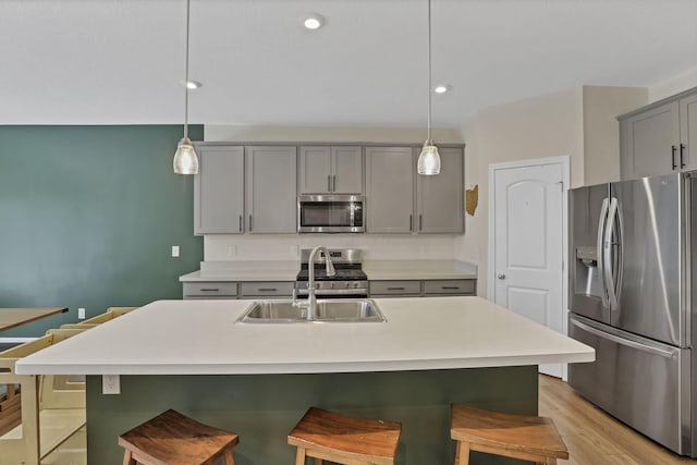 233 Dowler Dr, South Bloomfield, OH 43103 - kitchen featuring appliances with stainless steel finishes, gray cabinetry, a sink, a kitchen bar, and recessed lighting