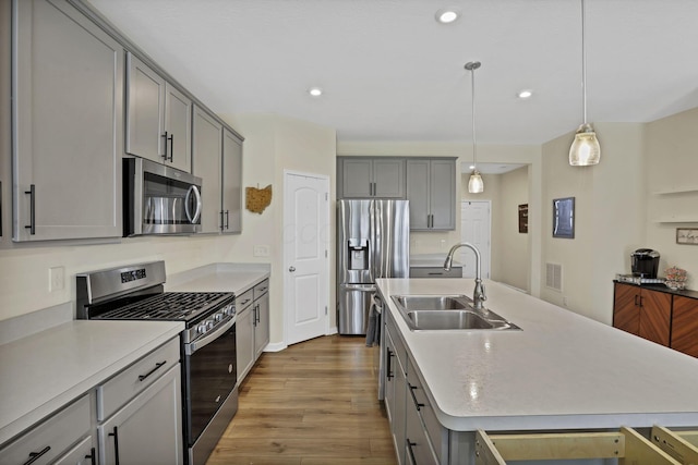 233 Dowler Dr, South Bloomfield, OH 43103 - kitchen with stainless steel appliances, a sink, gray cabinets, wood finished floors, and light countertops