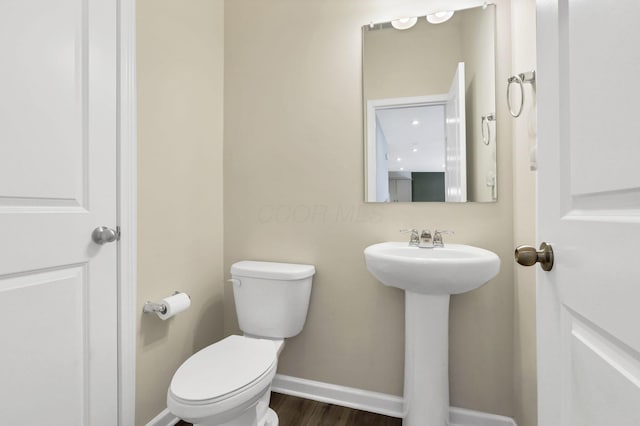 233 Dowler Dr, South Bloomfield, OH 43103 - bathroom featuring toilet, baseboards, wood finished floors, and a sink