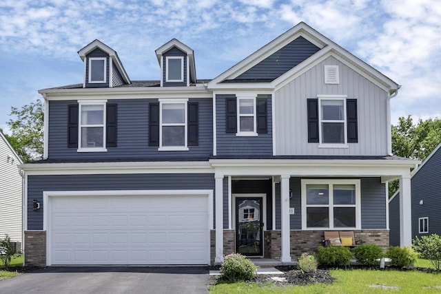 233 Dowler Dr, South Bloomfield, OH 43103 - craftsman inspired home with a porch, driveway, board and batten siding, a garage, and brick siding