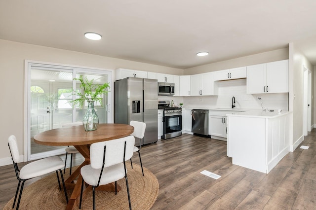 4795 Hafey Ave, Columbus, OH 43228 - kitchen with stainless steel appliances, a sink, dark wood-style floors, light countertops, and white cabinetry