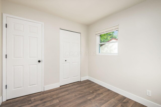4795 Hafey Ave, Columbus, OH 43228 - unfurnished bedroom with dark wood-type flooring, baseboards, and a closet