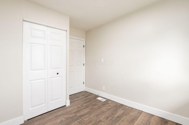 4795 Hafey Ave, Columbus, OH 43228 - unfurnished bedroom with wood finished floors, baseboards, and a closet