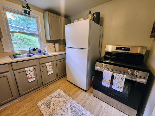 750 S 9th St, Cambridge, OH 43725 - kitchen featuring stainless steel range with electric stovetop, a sink, freestanding refrigerator, light countertops, and light wood-style flooring