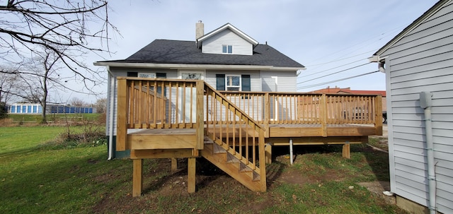 16 W Walnut St, Jeffersonville, OH 43128 - back of property with a chimney, a deck, a lawn, and roof with shingles