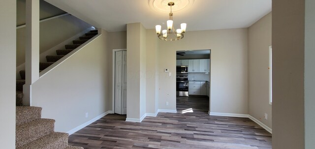 16 W Walnut St, Jeffersonville, OH 43128 - unfurnished dining area with wood finished floors, stairway, a chandelier, baseboards, and a ceiling fan