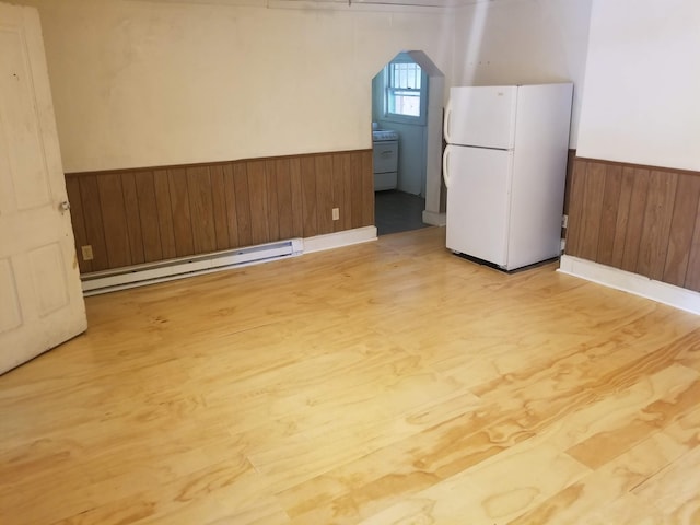 503-505 E 2nd St Unit 503, Chillicothe, OH 45601 - below grade area featuring freestanding refrigerator, a baseboard heating unit, a wainscoted wall, wooden walls, and arched walkways