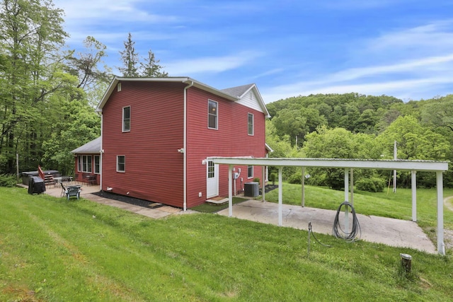 7485 Sugar Grove Rd SE, Sugar Grove, OH 43155 - view of side of home featuring a patio area, a yard, cooling unit, and a view of trees