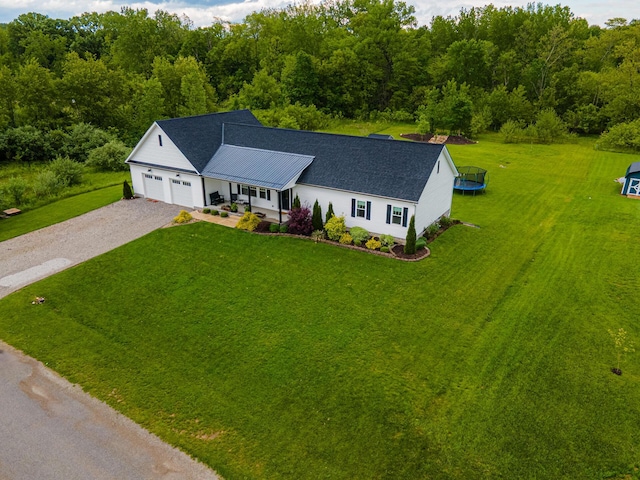 471 Quaker Trce, Marengo, OH 43334 - view of front of house with driveway, a trampoline, a front lawn, an attached garage, and roof with shingles
