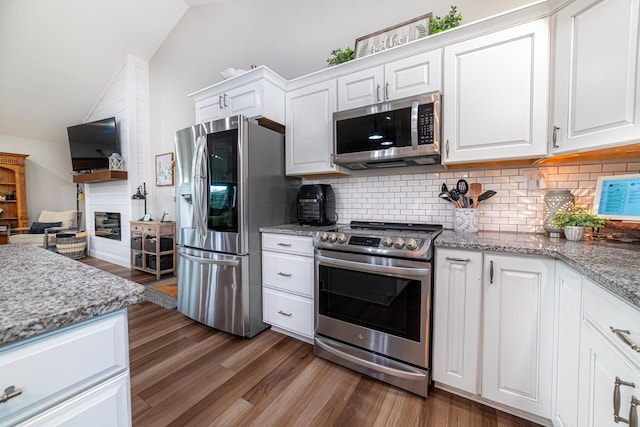 471 Quaker Trce, Marengo, OH 43334 - kitchen featuring stainless steel appliances, vaulted ceiling, wood finished floors, backsplash, and white cabinets