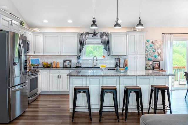 471 Quaker Trce, Marengo, OH 43334 - kitchen with stainless steel appliances, a sink, white cabinetry, a breakfast bar, and lofted ceiling